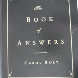 K&ouml;nnte beinhalten: Ein schwarzes Hardcover-Buch mit dem Titel "The Book of Answers" von Carol Bolt. Der Titel und der Name des Autors sind in wei&szlig;er Schriftart gehalten. Der Einband hat einen dekorativen Rahmen.