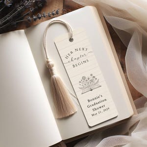Op de afbeelding: Beige bladwijzer met de tekst "HER NEXT chapter BEGINS" en een bloemenillustratie. De bladwijzer heeft een kwast en ligt in een open boek. De tekst "Bonnie's Graduation Shower May 21, 2029" staat ook op de bladwijzer.