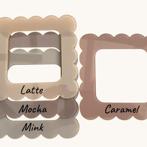 Op de afbeelding: Drie vierkante fotolijsten met geschulpte randen in de kleuren Latte, Mocha, Mink en Caramel. De namen van de kleuren staan in cursieve letters op de lijsten. De lijsten zijn gemaakt van een stevig materiaal.