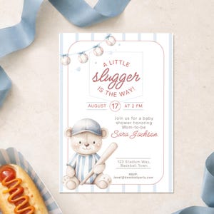 May include: Baby shower invitation with a baseball theme. The invitation features a teddy bear wearing a baseball cap and holding a bat. Text includes "A Little Slugger is the Way!" and event details.