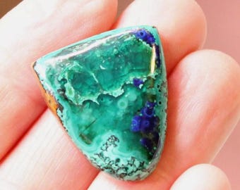 May include: A polished, triangular-shaped gemstone cabochon featuring a vibrant mix of marbled emerald green and deep royal blue mineral patterns with a smooth, glossy surface and natural, irregular dark veining throughout.