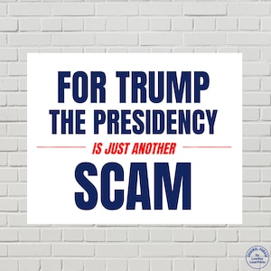 May include: A rectangular white sign featuring bold dark blue text that reads FOR TRUMP THE PRESIDENCY, followed by a thin red horizontal line, the red text IS JUST ANOTHER, and the large dark blue word SCAM at the bottom of the print.