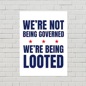 May include: White poster with the text "WE'RE NOT BEING GOVERNED" above "WE'RE BEING LOOTED" in navy blue. Three red stars are between the two phrases. The poster is against a white brick wall.
