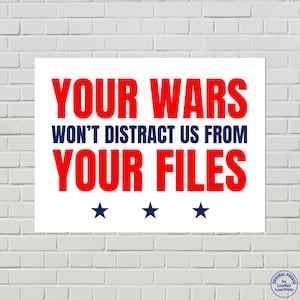 May include: White rectangular poster with the text "YOUR WARS WON'T DISTRACT US FROM YOUR FILES" in red and blue. Three blue stars are at the bottom. The poster is against a white brick wall.
