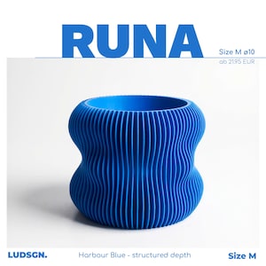 Puede incluir: Una maceta azul, cilíndrica, con una textura acanalada. La maceta tiene una forma única de reloj de arena y está etiquetada como "RUNA" en letras azules grandes. También es visible el texto "Harbour Blue - structured depth".