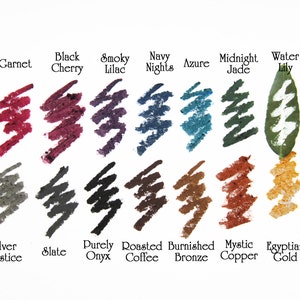 Może przedstawiać: Pr&oacute;bki kredek kosmetycznych w r&oacute;żnych kolorach, w tym Garnet, Black Cherry, Smoky Lilac, Navy Nights, Azure, Midnight Jade i Water Lily. Dodatkowe odcienie to Silver Solstice, Slate, Purely Onyx, Roasted Coffee, Burnished Bronze, Mystic Copper i Egyptian Gold.