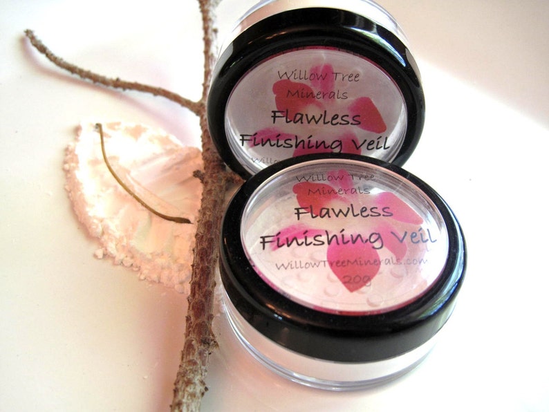 May include: Two clear plastic containers with black lids containing a white powder. The lids have a pink floral design and the text "Willow Tree Minerals Flawless Finishing Veil" printed on them.
