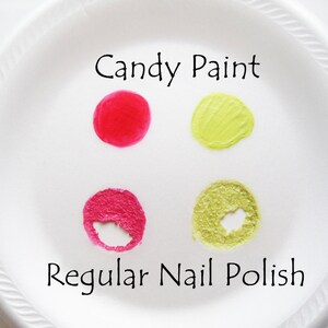 May include: A white plate with four samples of nail polish. Two samples are labeled "Candy Paint" and are a bright red and a light green. The other two samples are labeled "Regular Nail Polish" and are a darker pink and a light green.