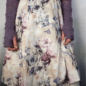 May include: Purple knitted arm warmers with a floral print dress and the text "INNER WILD" and "LOVEY ARM WARMERS".
