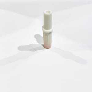 May include: A white and pink bottle stopper with a cylindrical design. The stopper has a rounded top and a flared base, with a pink hue at the bottom. The object is set against a white background.