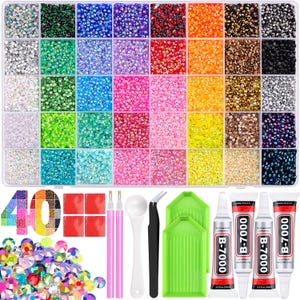 May include: A rectangular storage case containing 40 compartments filled with small, multi-colored rhinestones in various hues. Included are two pink applicator pens, a white scoop, black tweezers, two green trays, and four tubes of B-7000 adhesive.