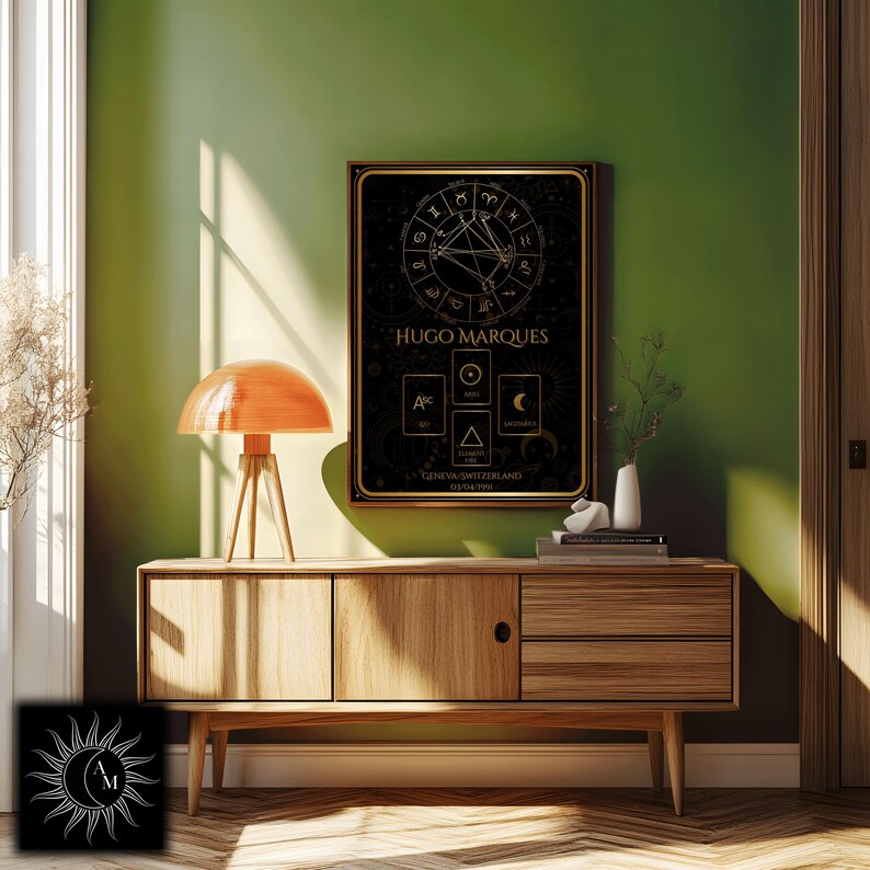 Peut inclure: Un tableau noir et dor&eacute; encadr&eacute; avec un th&egrave;me astrologique, portant le nom "HUGO MARQUES", est accroch&eacute; sur un mur vert. Il pr&eacute;sente des symboles du zodiaque et des motifs g&eacute;om&eacute;triques. Un meuble en bois avec une lampe orange et des objets d&eacute;coratifs est en dessous.