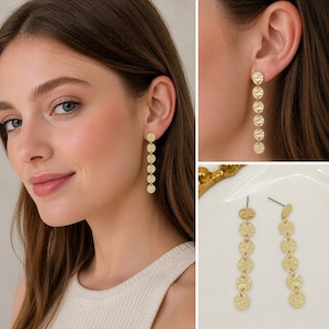 May include: Gold-colored dangle earrings featuring a series of textured, circular discs. The earrings are shown on a person's ear and also displayed separately. The earrings are a simple yet elegant accessory.