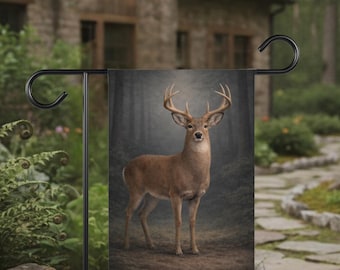 May include: A garden flag depicting a stag with impressive antlers, set against a backdrop of a misty forest. The flag is displayed on a black metal stand, with a stone pathway and a house in the background.