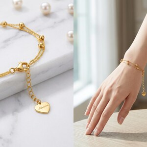 Elegant woman's hand wearing 18K gold bracelet on white marble desk
