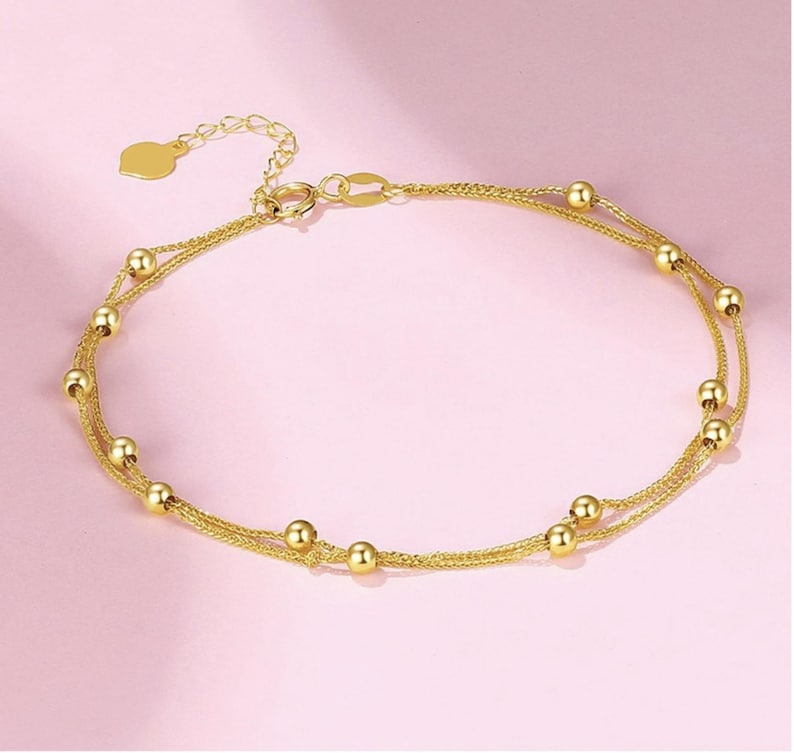 18K gold double row Chopin Starry Sky bracelet on blush pink background