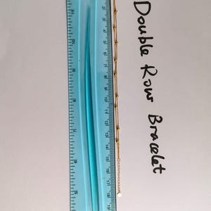 18K gold double row bracelet next to ruler showing chain measurements