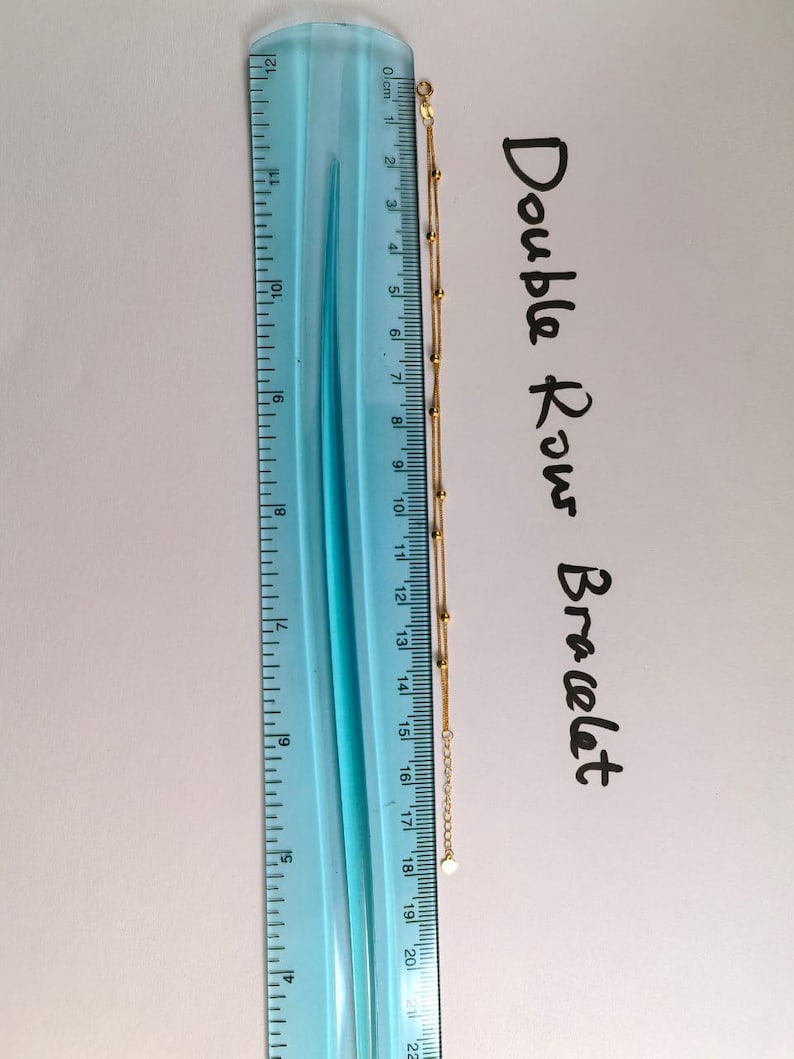 18K gold double row bracelet next to ruler showing chain measurements