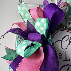 May include: A white ceramic mug with a black handle and the text "But First, Coffee" in a black, handwritten-style font. The mug is on a white surface.