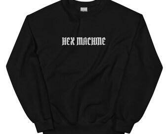 May include: Black crewneck sweatshirt with the text "HEX MACHINE" in a gothic font across the chest. The sweatshirt is a solid black color and has a ribbed neckline, cuffs, and hem.