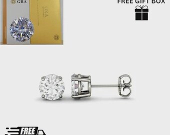 May include: Diamond stud earrings with a round, brilliant-cut design, set in silver metal. The image includes a GRA certificate and a gift box icon. The earrings are a classic jewellery item.