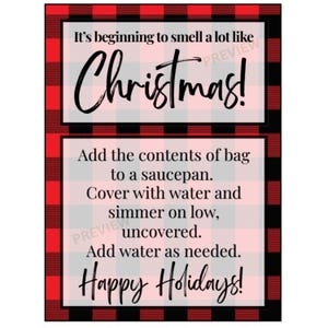 Könnte beinhalten: Ein festliches Weihnachtsschild mit einem rot-schwarzen Büffel-Plaid-Rand. Das Schild enthält den Text "It's beginning to smell a lot like Christmas!" und Rezeptanweisungen, die mit "Happy Holidays!" enden.