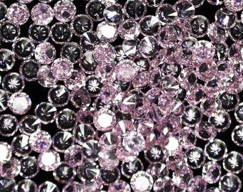 Puede incluir: Primer plano de numerosas gemas rosas redondas y facetadas, posiblemente diamantes, sobre un fondo oscuro. Las gemas reflejan la luz, creando un efecto brillante. La imagen transmite una sensación de lujo y sofisticación.