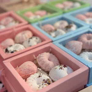 Puede incluir: Una taza de cerámica blanca con un asa negra y el texto "But First, Coffee" en negro, en negrita. La taza está sobre una superficie blanca.