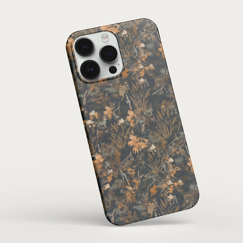 May include: A smartphone case with a camouflage pattern featuring brown, tan, and green foliage. The case has a glossy finish and a camera cutout. The design resembles a forest scene, offering a nature-inspired aesthetic.