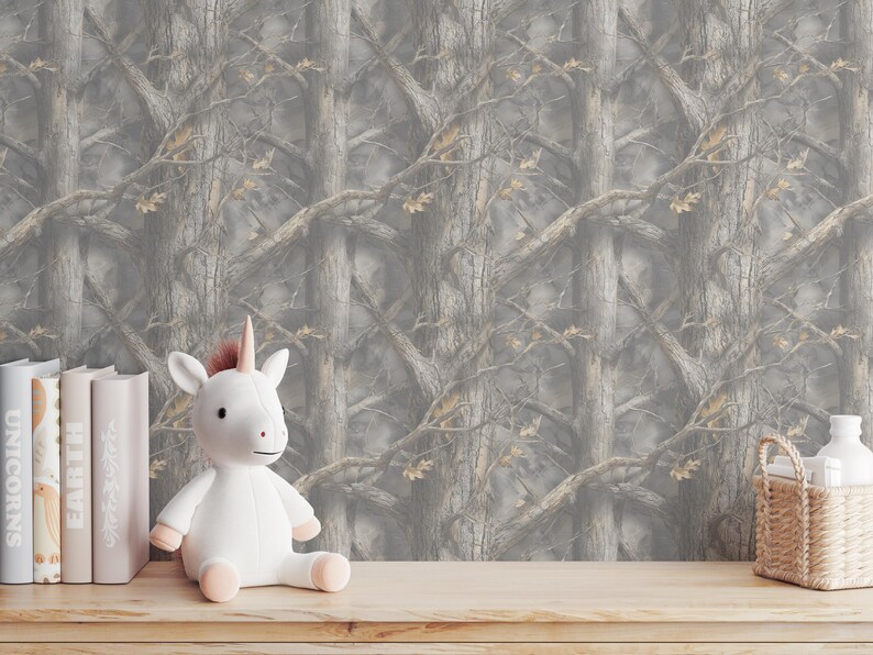May include: A white unicorn plush toy with a pink horn and hooves sits on a wooden surface. Behind it is a backdrop of a gray and brown tree pattern. Books and a small basket are also on the surface.