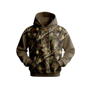 Puede incluir: Una sudadera con capucha de camuflaje con capucha, mangas y bolsillo marrones. La parte delantera de la sudadera con capucha presenta un patr&oacute;n forestal detallado con hojas y ramas. La sudadera con capucha tiene un cord&oacute;n y un bolsillo de canguro.