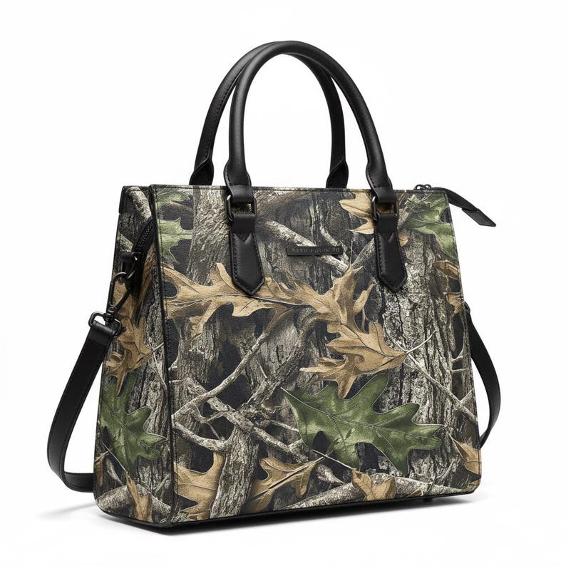 Puede incluir: Bolso con estampado de camuflaje con asas negras y bandolera. El bolso presenta un estampado realista de corteza de &aacute;rbol y hojas en tonos marr&oacute;n, verde y beige. El bolso tiene forma rectangular con cierre de cremallera.