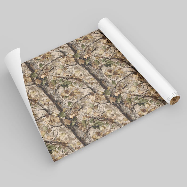 Puede incluir: Una hoja de papel enrollada que presenta un patr&oacute;n de camuflaje. El dise&ntilde;o incorpora ramas de &aacute;rboles, hojas y una mezcla de tonos marrones, beige y verdes, creando una est&eacute;tica natural de bosque.