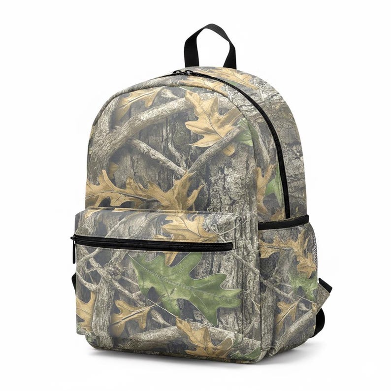 Puede incluir: Una mochila de camuflaje con cremallera negra, asa y bolsillo lateral de malla. La mochila presenta un patr&oacute;n de corteza de &aacute;rbol marr&oacute;n y hojas, con una hoja verde visible en el bolsillo delantero.