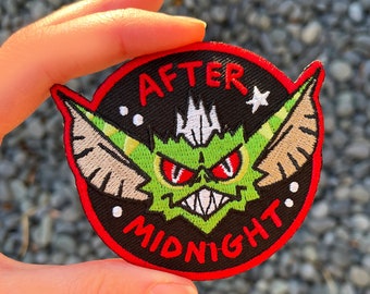 May include: A black and red embroidered patch with a green, red-eyed creature with large ears and the text "AFTER MIDNIGHT" in white.