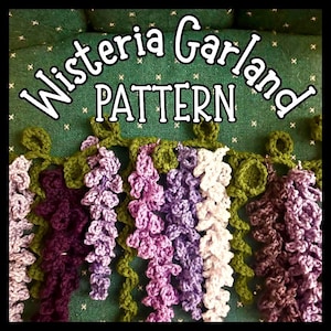 Peut inclure: Un patron de guirlande de glycine au crochet, avec le texte "Wisteria Garland PATTERN". La guirlande présente des grappes de fleurs violettes, lavande et blanches, reliées par des vignes vertes. Le fond est un tissu vert texturé.