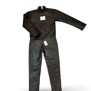 以下が含まれることがあります： 黒いキルティングジャケットとパンツのセット。ジャケットはハイネックで、ダイヤモンド柄です。パンツは縦のラインが入っています。どちらのアイテムにもタグが付いています。セットは光沢のある素材で作られています。