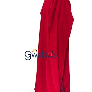 Puede incluir: Prenda larga y fluida de color rojo, con cuello alto y mangas largas. La prenda tiene una abertura lateral, revelando un vistazo del interior. El logotipo "Gwabo's" es visible en la esquina inferior izquierda.