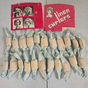 May include: A collection of beige fabric hair curlers with blue stitched edges, accompanied by two vintage red and white instructional paper inserts featuring the text Linen Curlers for Beautiful Hair and instructions.