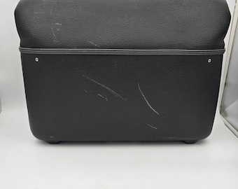 Mala de viagem vintage American Tourister em vinil preto, rígida, estilo clássico dos anos 1960.