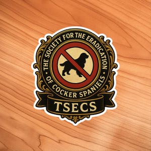 May include: A sticker with a circular emblem featuring a black silhouette of a Cocker Spaniel inside a red prohibition sign. The emblem is surrounded by text that reads "THE SOCIETY FOR THE ERADICATION OF COCKER SPANIELS" and "TSECS".