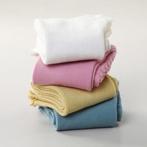 May include: A stack of folded socks in various pastel colors: white, pink, yellow, and blue. The socks are neatly arranged, showcasing their soft texture and ribbed design. The image is set against a plain white background.