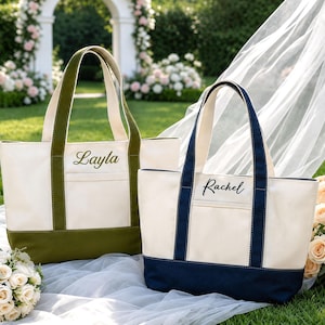 May include: Two canvas tote bags with dual handles and an exterior pocket. One bag features olive green trim and the name Layla embroidered in green. The other bag features navy blue trim and the name Rachel embroidered in black.