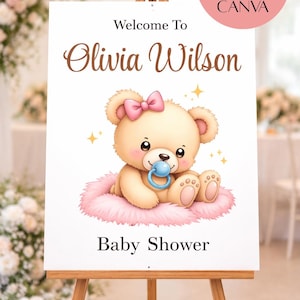 Op de afbeelding: Een babyborrelbord op een ezel met een teddybeerillustratie met een roze strik en fopspeen. Op het bord staat "Welkom bij Olivia Wilson" en "Baby Shower". Het bord is verkrijgbaar in 5 maten.