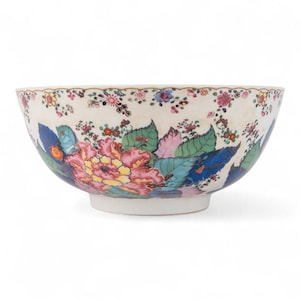 May include: A decorative ceramic bowl with a floral design. The bowl features a cream-colored base with a colorful pattern of pink, yellow, blue, and green flowers and leaves. The rim is adorned with a delicate gold trim.