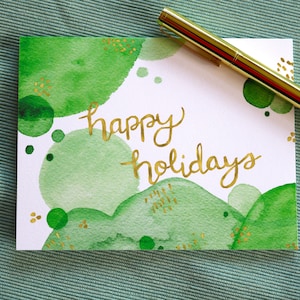 Buone vacanze, cartolina d'auguri di Natale con acquerello verde astratto, set di cancelleria piegato in bianco illustrato con calligrafia dorata