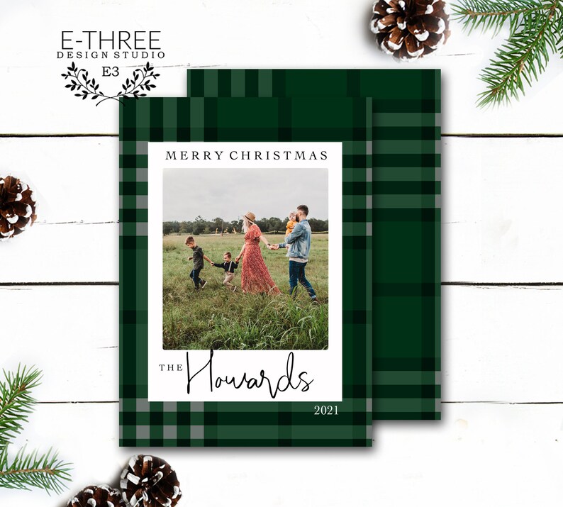 May include: A green and white plaid Christmas card with a photo of a family of four in a field. The text "Merry Christmas" is at the top of the card, and the text "The Howards 2021" is at the bottom.