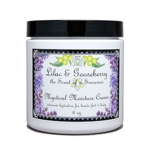 Peut inclure: Pot en verre blanc avec un couvercle noir et une étiquette indiquant "Lilac & Gooseberry the Scent of a Sorceress Mystical Moisture Cream hydratation intensive pour les mains, les pieds et le corps 8 oz."