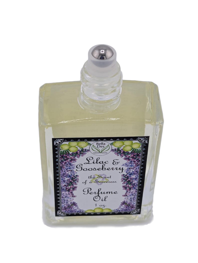 Op de afbeelding: Een heldere, rechthoekige parfumolie fles met een zilveren dop. Het etiket toont de tekst "Lilac & Gooseberry" en "Perfume Oil" met bloemen- en bladerillustraties. De fles bevat 29.57 ml parfumolie.