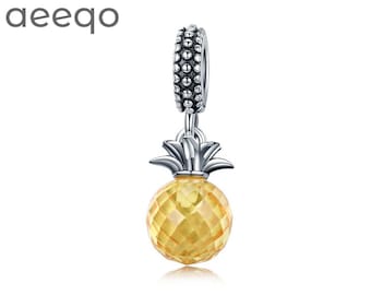 May include: A silver charm in the shape of a pineapple with a yellow crystal. The charm has a detailed design and is perfect for adding a touch of tropical flair to your jewelry.